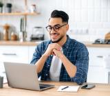Laechelnder Mann vor Laptop als Symbolbild fuer das VMware vSphere v9 Training online